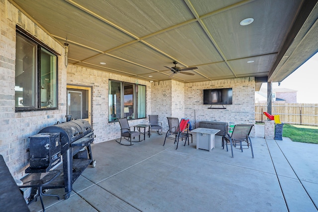 view of patio / terrace featuring grilling area, ceiling fan, and an outdoor fireplace