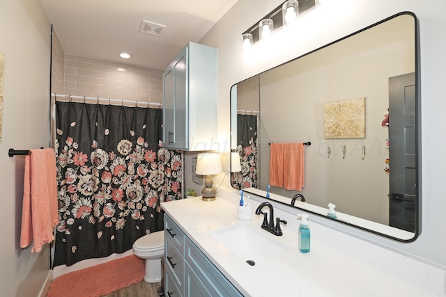 bathroom with vanity, toilet, wood-type flooring, and walk in shower