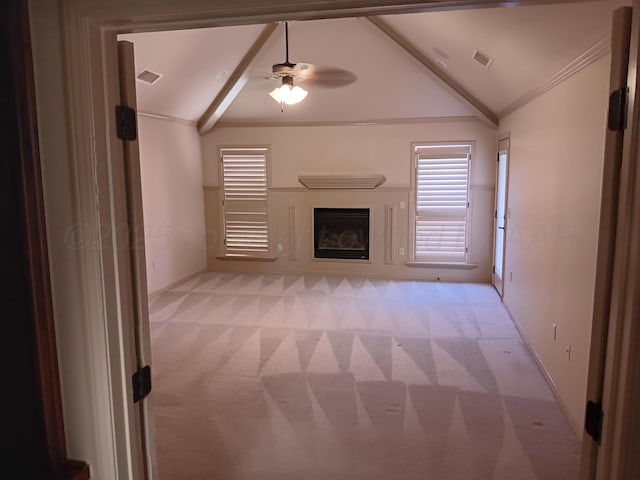 unfurnished living room featuring crown molding, a fireplace, lofted ceiling, light colored carpet, and visible vents