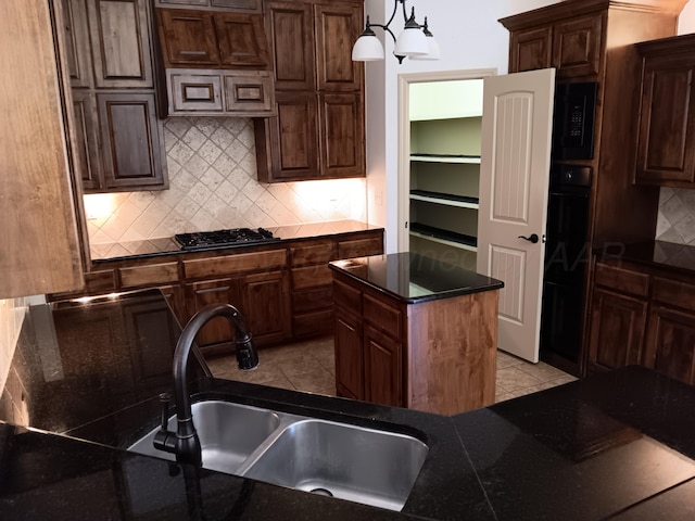 kitchen with light tile patterned flooring, a sink, backsplash, black appliances, and dark countertops