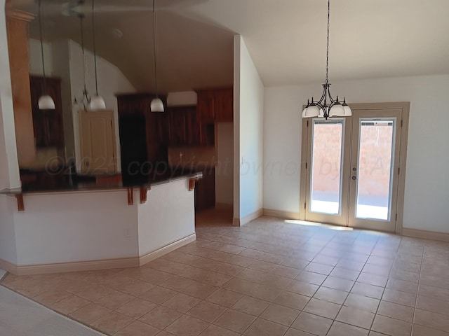 kitchen featuring dark countertops, a peninsula, a kitchen breakfast bar, and light tile patterned floors