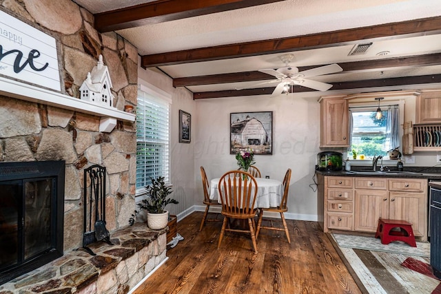 1203 Lee St, Borger, TX 79007 - dining area featuring dark wood finished floors, baseboards, a fireplace, beamed ceiling, and a ceiling fan
