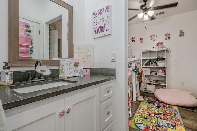 bathroom featuring wood finished floors, a ceiling fan, vanity, and visible vents