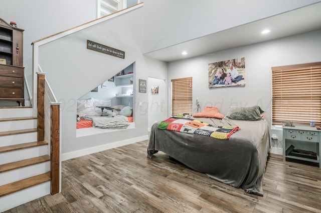 bedroom with baseboards, wood finished floors, and recessed lighting