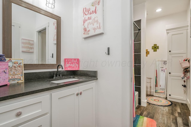 full bathroom with recessed lighting, wood finished floors, and vanity