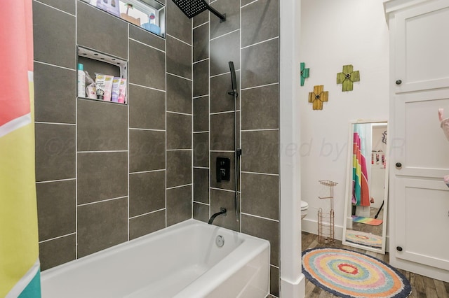 bathroom with tub / shower combination, wood finished floors, toilet, and baseboards