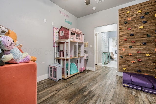 interior space featuring ceiling fan, baseboards, wood finished floors, and visible vents