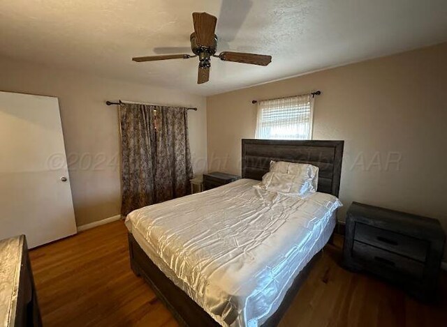 bedroom featuring ceiling fan and dark hardwood / wood-style floors