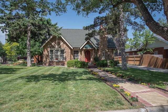 english style home featuring a front yard