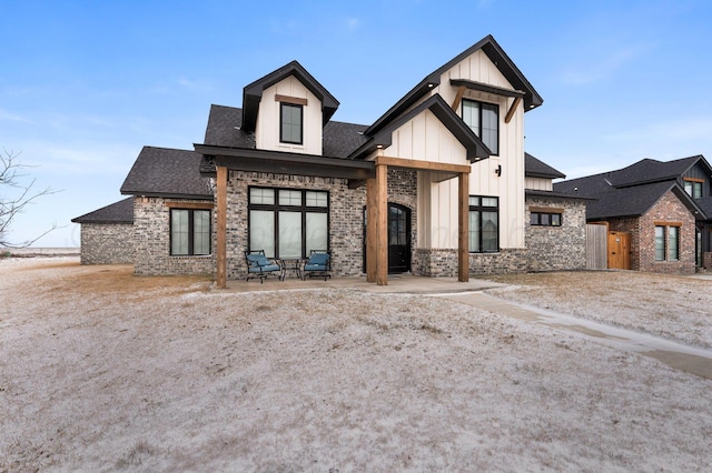 modern farmhouse style home with stone siding, a shingled roof, and board and batten siding