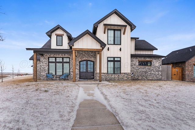 modern farmhouse featuring stone siding and board and batten siding