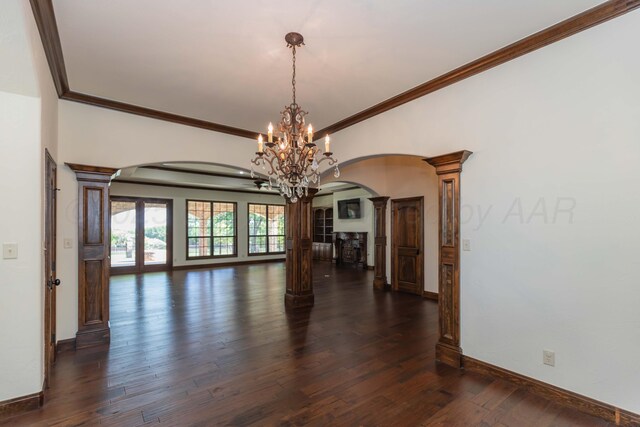 3 Country Club Dr, Amarillo, TX 79124 - empty room featuring arched walkways, decorative columns, a chandelier, dark wood-type flooring, and ornamental molding