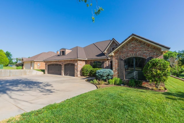 3 Country Club Dr, Amarillo, TX 79124 - french country style house featuring an attached garage, concrete driveway, brick siding, a front yard, and stone siding