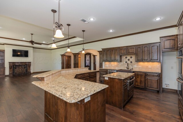 3 Country Club Dr, Amarillo, TX 79124 - kitchen featuring a spacious island, arched walkways, ornamental molding, a ceiling fan, and a fireplace