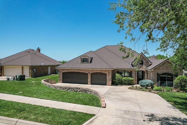 3 Country Club Dr, Amarillo, TX 79124 - french country style house with driveway, an attached garage, brick siding, a front yard, and a tiled roof