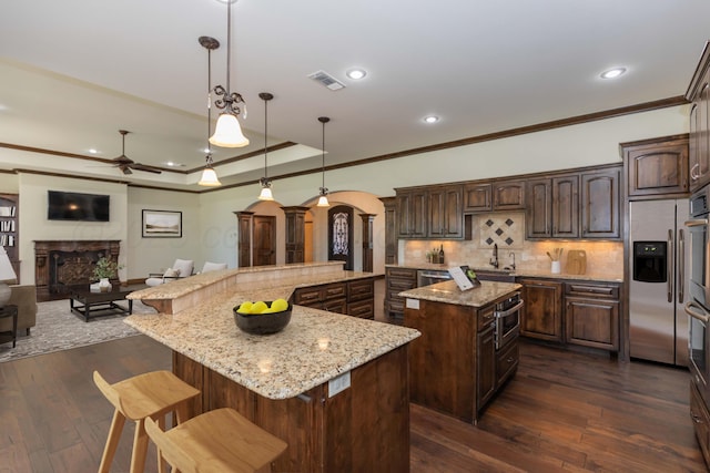 3 Country Club Dr, Amarillo, TX 79124 - kitchen featuring a spacious island, arched walkways, ornamental molding, ceiling fan, and a fireplace