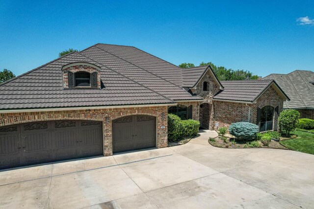 3 Country Club Dr, Amarillo, TX 79124 - french country home with a tile roof, driveway, brick siding, and an attached garage