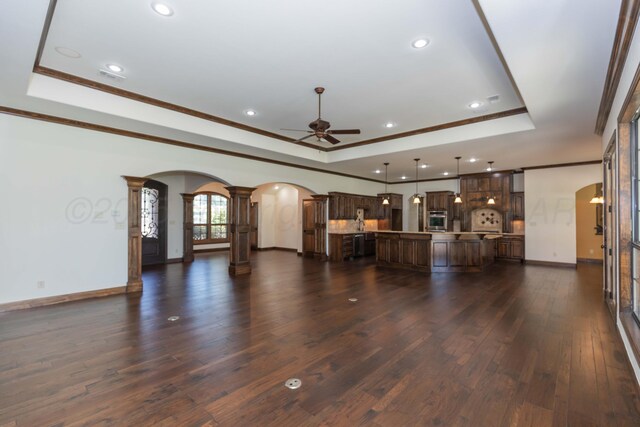 3 Country Club Dr, Amarillo, TX 79124 - unfurnished living room with a tray ceiling, arched walkways, ornate columns, ornamental molding, and recessed lighting