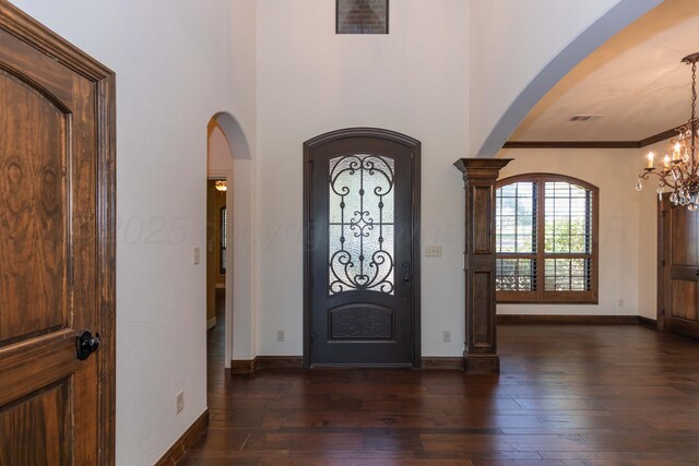 3 Country Club Dr, Amarillo, TX 79124 - foyer entrance with arched walkways, dark wood-style floors, a chandelier, and crown molding