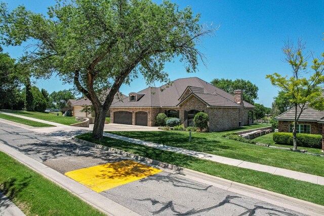 3 Country Club Dr, Amarillo, TX 79124 - view of front of property with concrete driveway, a front lawn, stone siding, a tile roof, and a garage