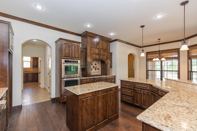 3 Country Club Dr, Amarillo, TX 79124 - kitchen featuring double oven, arched walkways, a center island, crown molding, and dark brown cabinets