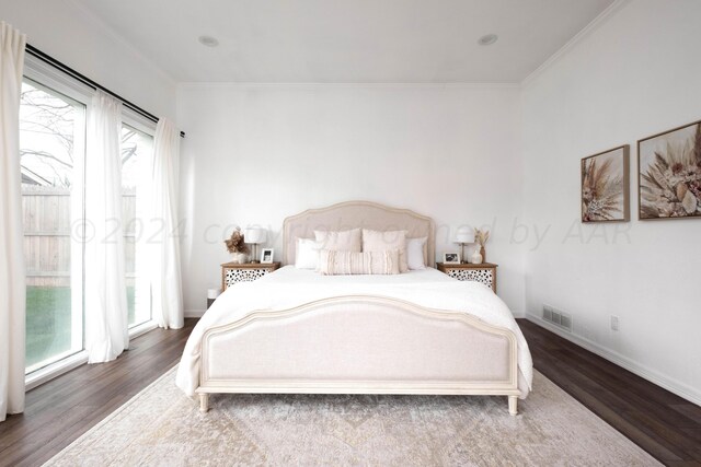 bedroom featuring multiple windows, hardwood / wood-style flooring, and crown molding