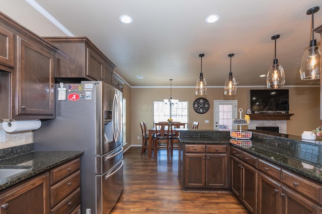 7116 Bennett St, Amarillo, TX 79119 - kitchen featuring dark wood finished floors, decorative backsplash, crown molding, recessed lighting, and hanging light fixtures