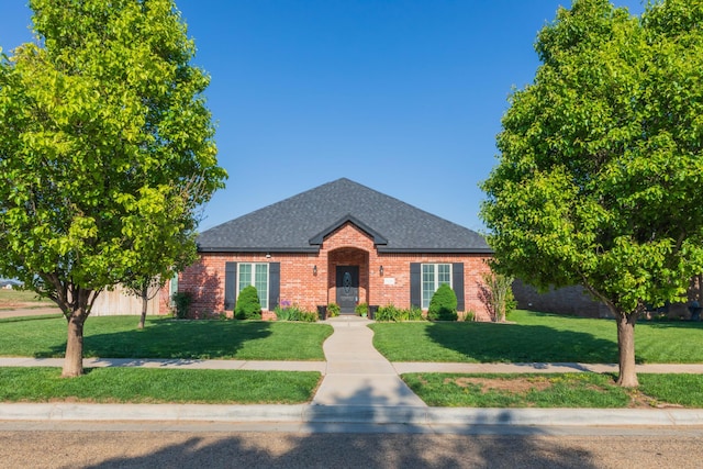 7116 Bennett St, Amarillo, TX 79119 - view of front of home with roof with shingles, a front yard, and brick siding