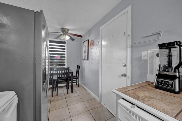 4215 S Tyler St, Amarillo, TX 79110 - kitchen with freestanding refrigerator, a ceiling fan, light tile patterned floors, a textured ceiling, and light countertops