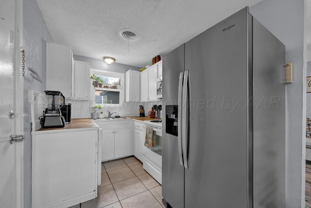 4215 S Tyler St, Amarillo, TX 79110 - kitchen with appliances with stainless steel finishes, white cabinetry, decorative backsplash, and a textured ceiling