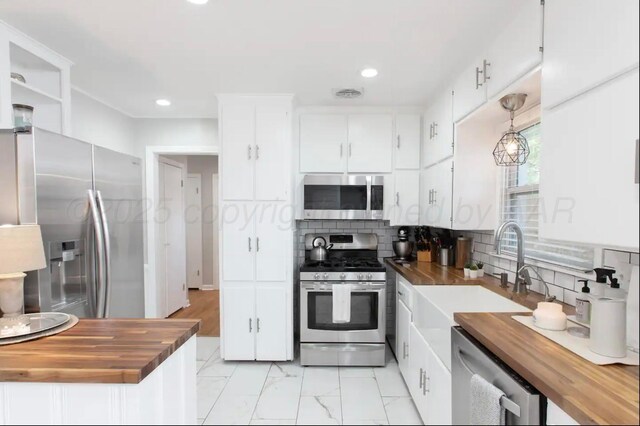 2406 Anna St, Amarillo, TX 79106 - kitchen with appliances with stainless steel finishes, butcher block counters, tasteful backsplash, white cabinetry, and recessed lighting