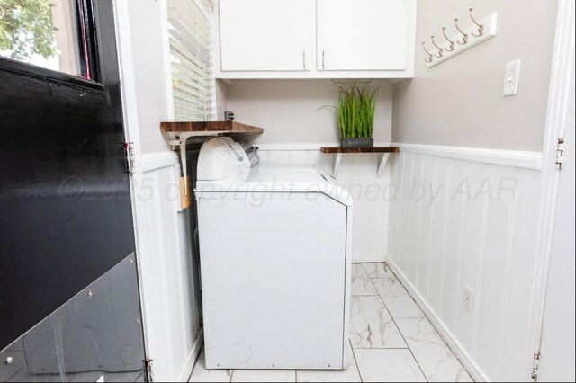 2406 Anna St, Amarillo, TX 79106 - laundry room featuring light marble finish floors, a wainscoted wall, washer and clothes dryer, and cabinet space