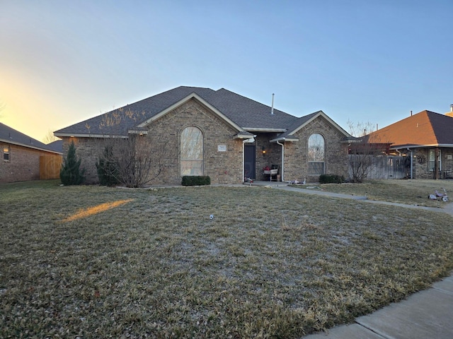 ranch-style home featuring a lawn