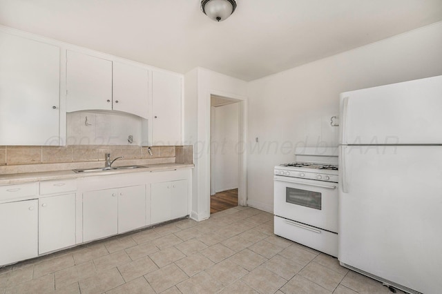 kitchen with white appliances, light countertops, a sink, and white cabinets