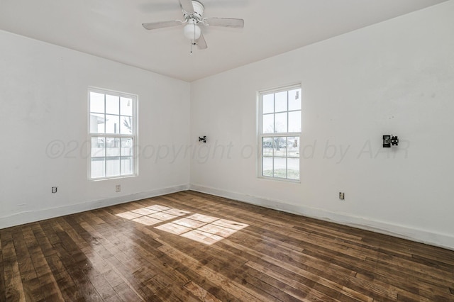 empty room featuring baseboards, dark wood finished floors, and a ceiling fan