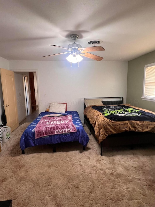 carpeted bedroom with visible vents and ceiling fan