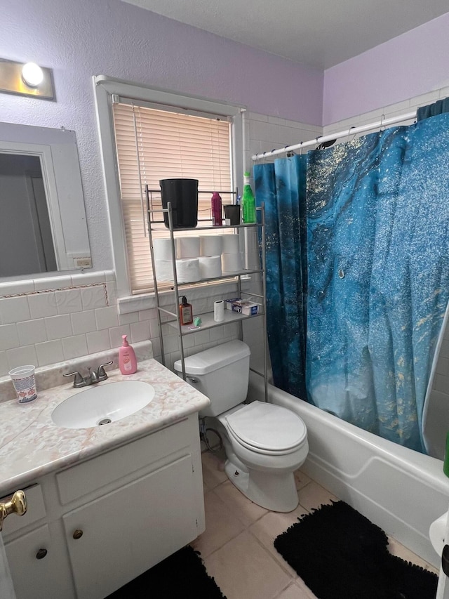 bathroom with tile patterned floors, toilet, tile walls, shower / tub combo, and vanity