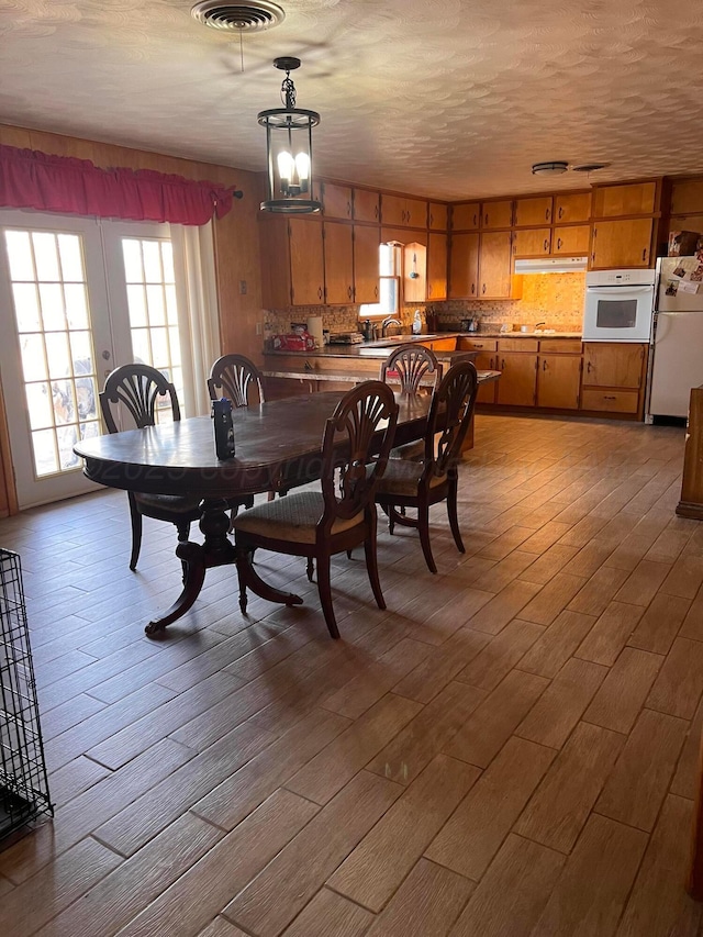 dining room featuring visible vents, a textured ceiling, and wood finished floors