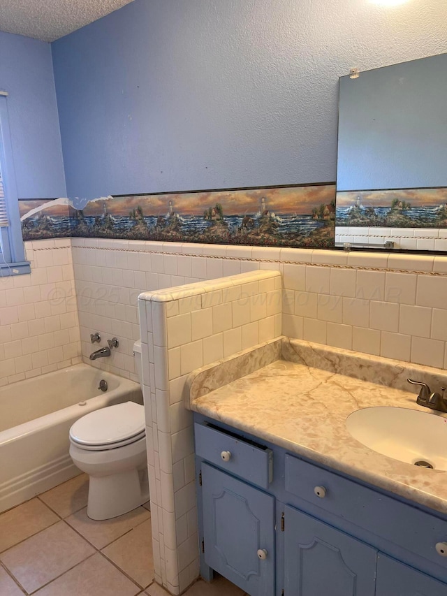 bathroom with vanity, a bathing tub, a textured ceiling, tile patterned floors, and toilet