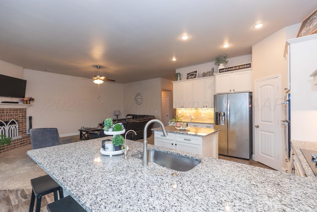 9310 Rockwood Dr, Amarillo, TX 79119 - kitchen featuring ceiling fan, stainless steel refrigerator with ice dispenser, a sink, white cabinets, and open floor plan
