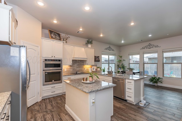 9310 Rockwood Dr, Amarillo, TX 79119 - kitchen with a kitchen island, dark wood-style flooring, custom range hood, a sink, and stainless steel appliances