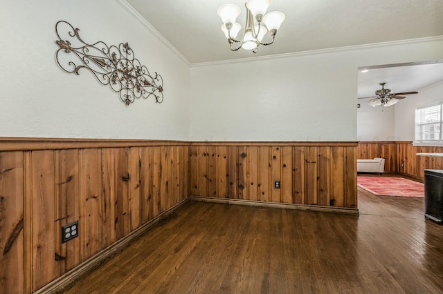 spare room with crown molding, dark hardwood / wood-style floors, and ceiling fan with notable chandelier