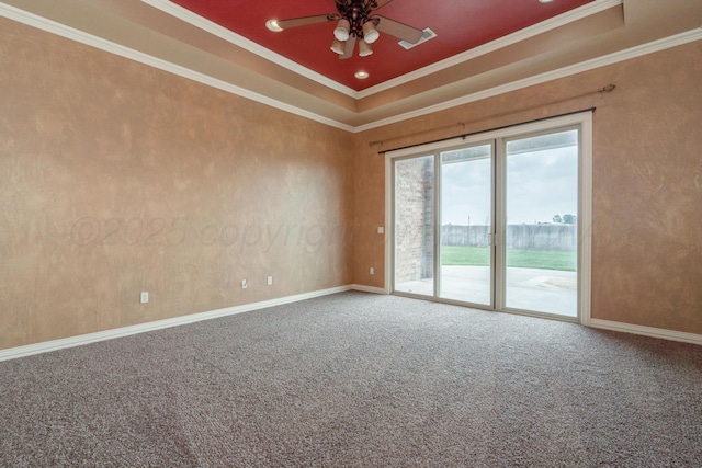 carpeted spare room with crown molding, baseboards, a ceiling fan, and a raised ceiling