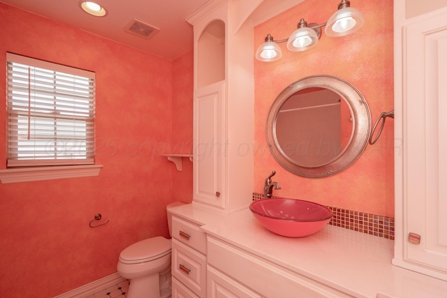 bathroom with vanity, toilet, recessed lighting, baseboards, and visible vents