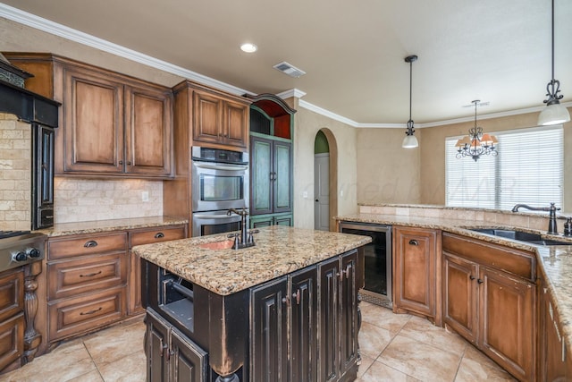 kitchen featuring a sink, arched walkways, beverage cooler, stainless steel appliances, and visible vents