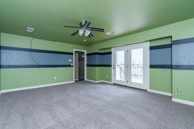 spare room with carpet floors, ceiling fan, visible vents, and baseboards