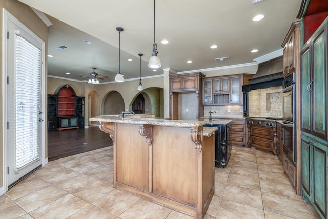 kitchen with arched walkways, ornamental molding, a breakfast bar, and backsplash