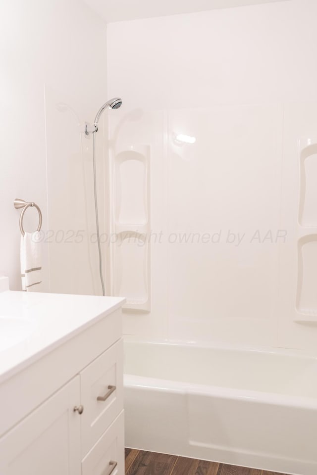 508 S Austin St, Shamrock, TX 79079 - bathroom featuring wood finished floors, vanity, and tub / shower combination