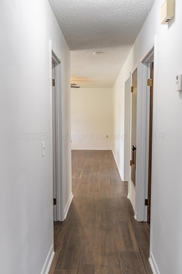 508 S Austin St, Shamrock, TX 79079 - hallway featuring a textured ceiling and dark wood-type flooring