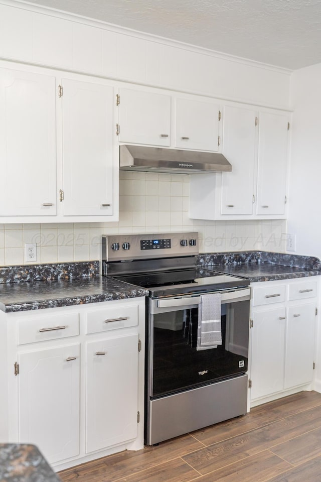 508 S Austin St, Shamrock, TX 79079 - kitchen featuring electric range, under cabinet range hood, white cabinets, dark wood-style floors, and ornamental molding